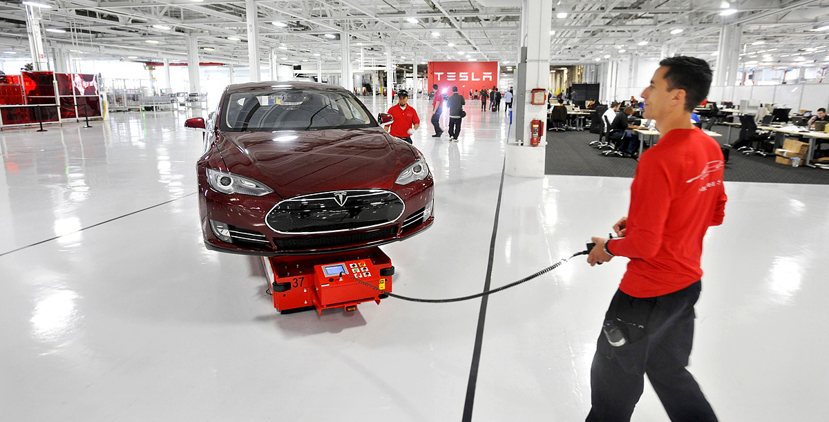 Mark Cuyler, an operations manager at Tesla, walks a Model S through the company's factory in Fremont, California, June 22, 2012. Tesla began delivering the electric sedan to customers on June 22. REUTERS/Noah Berger (UNITED STATES - Tags: TRANSPORT 