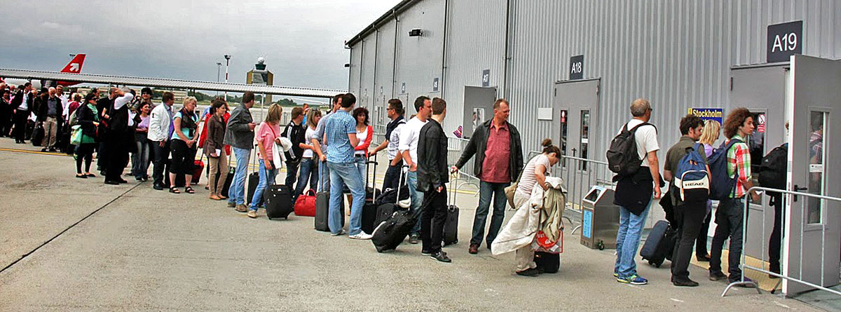 Gépükre váró utasok igyekeznek bejutni az új beszállókapukhoz