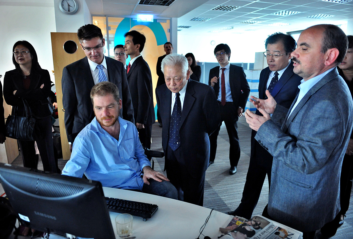Tóth Levente, a Népszabadság megbízott főszerkesztője (jobbra) mutatja Zhou Tienongnak (középen) a honlap felépítését