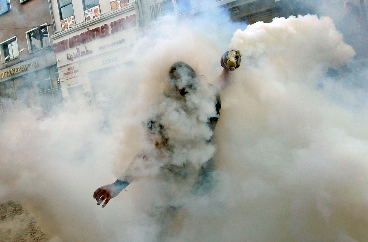 A demonstrator throws back a tear gas canister to riot police during an anti-government protest in central Istanbul May 31, 2013. Turkish police fired tear gas and water cannon on Friday at demonstrators in central Istanbul, wounding scores of people