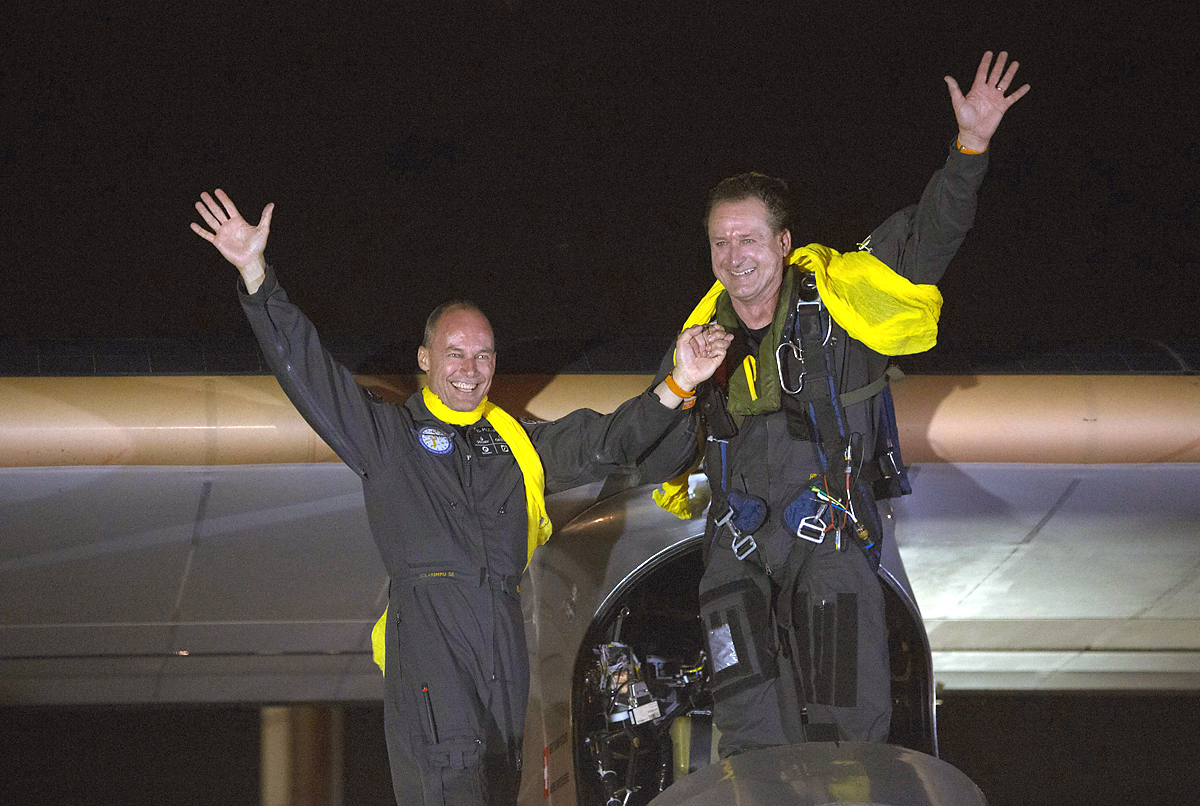 Pilots and founders Bertrand Piccard and Andre Borschberg (R) wave to the crowd after Solar Impulse lands at JFK airport in New York July 6, 2013. The airplane entirely powered by the sun touched down in New York City late on Saturday, completing the