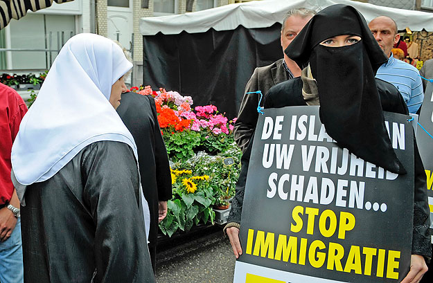 Filip Dewinter, a flamand szélsőjobboldali Vlaams Belang vezetője egy burkás asszonnyal a bevándorlók ellen kampányol