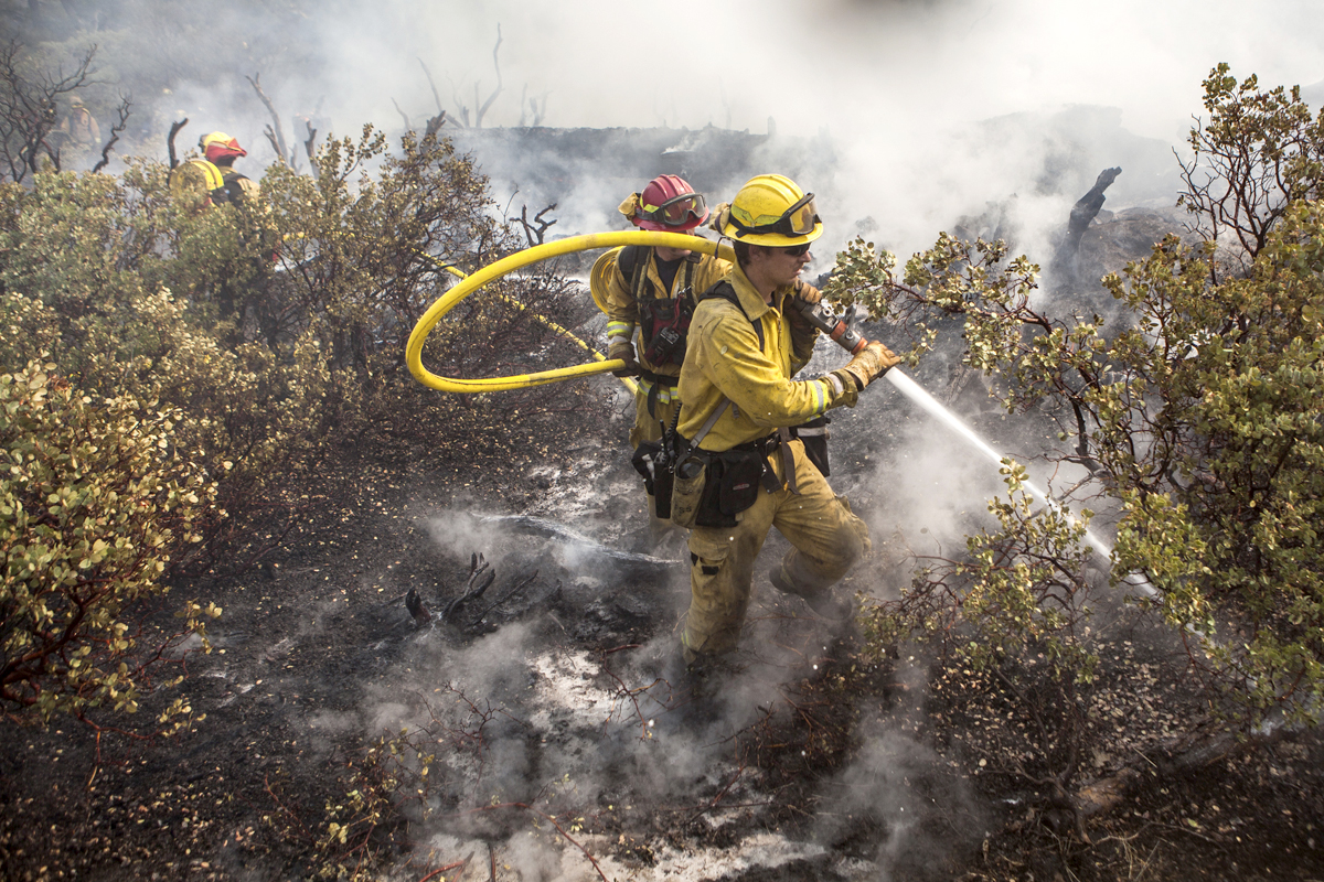 A firefighting crew puts out a spot fire that jumped a fire line in Yosemite National Park, California, August 23, 2013. The 105,000-acre Rim Fire, named for a Stanislaus National Forest lookout point called Rim of the World, has destroyed four homes