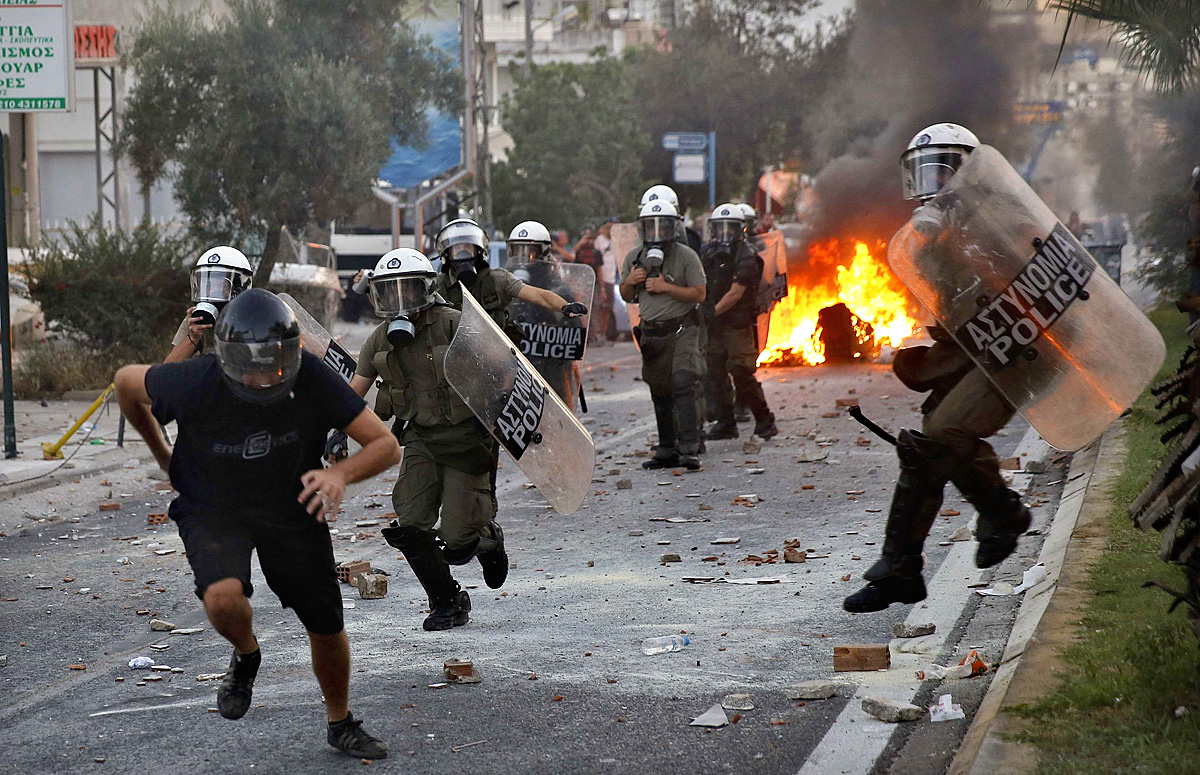 Rendőrök kergetnek egy antifasiszta tüntetőt Athénban