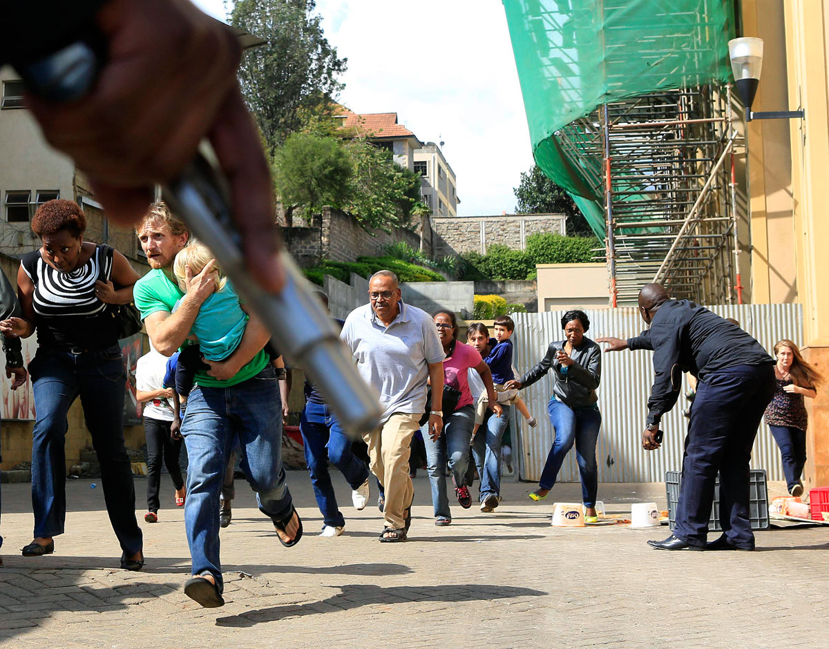 A terrortámadás után rendőrök nyújtanak fedezéket a plázából menekülő vásárlóknak
