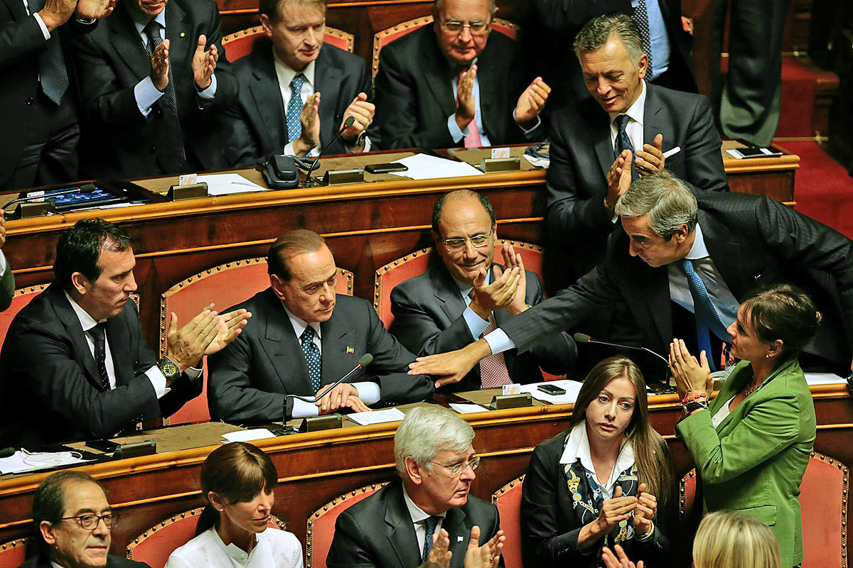 Párttársai gratulálnak Berlusconinak (balról a második) a szenátusban tartott szavazás után