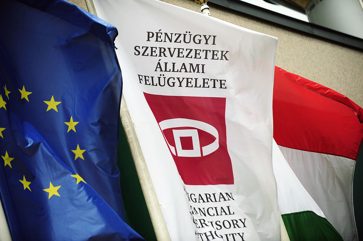 Archív: zászlók a felszámolt felügyelet székháza előtt. Az uniós jegybank a PSZÁF–MNB-összevonás gyorsasága miatt bírálja a kormányt