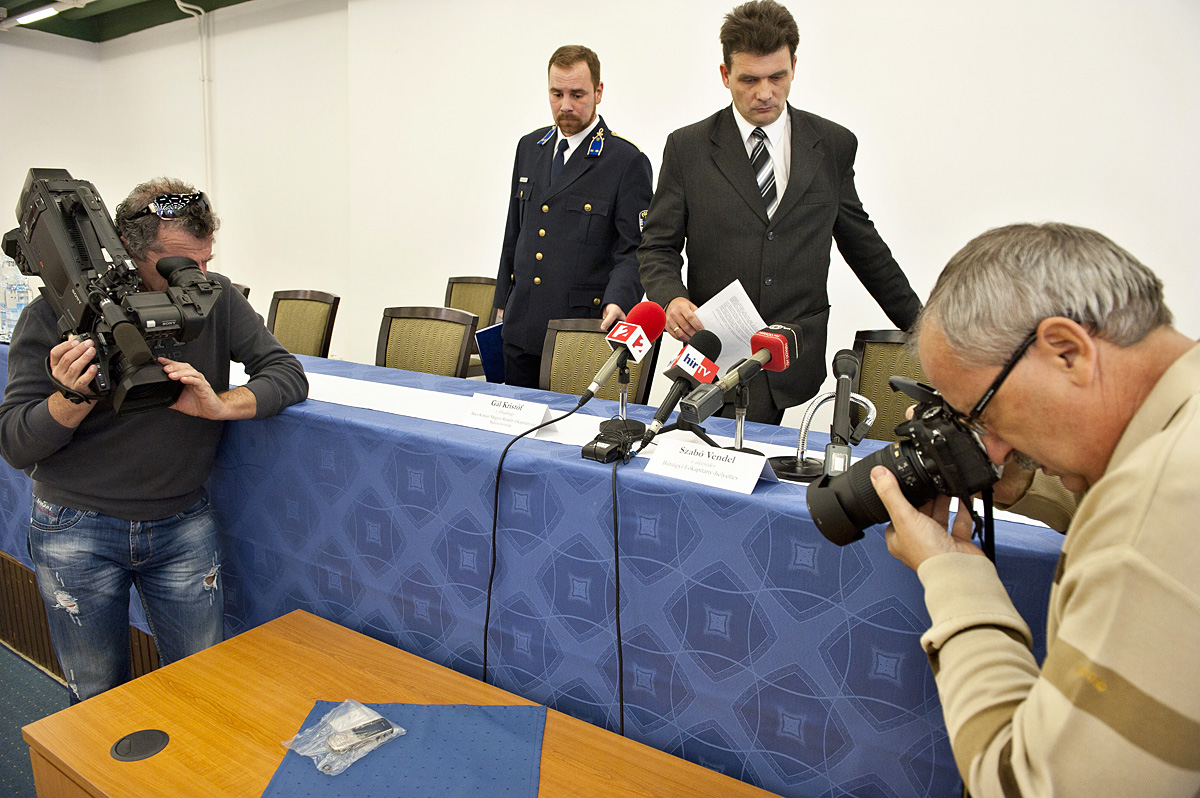 A sajtó a tárgyi bizonyítékokat fotózza Szabó Vendel rendőr alezredes, a főkapitány bűnügyi helyettese és Gál Kristóf rendőrségi szóvivő tájékoztatása előtt
