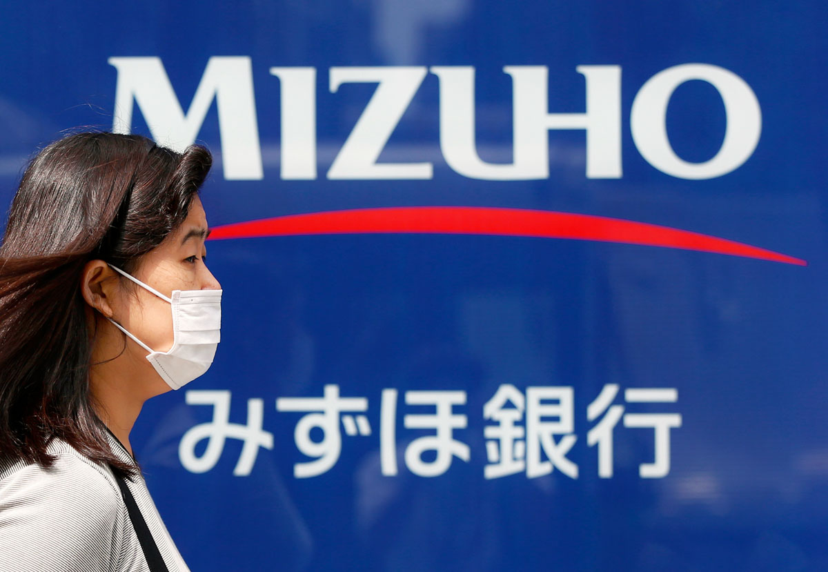 Járókelő a botrányba keveredett Mizuho bank egyik tokiói fiókja előtt