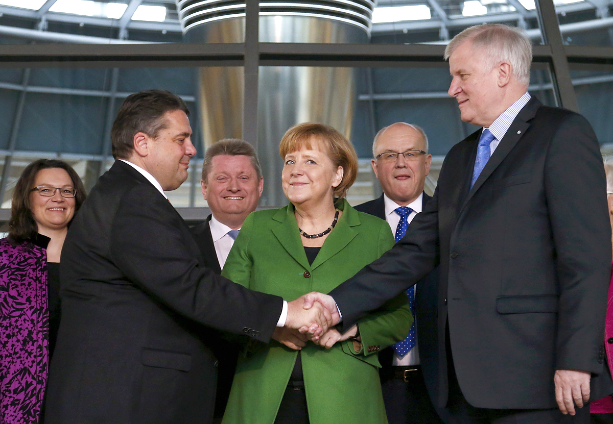 Gabriel és Seehofer kézfogása szerdán, a német nagykoalíciós megállapodás bejelentésekor, Angela Merkel kancellár társaságában. Csak védeni akarta aaz újdonsült szövetségest?