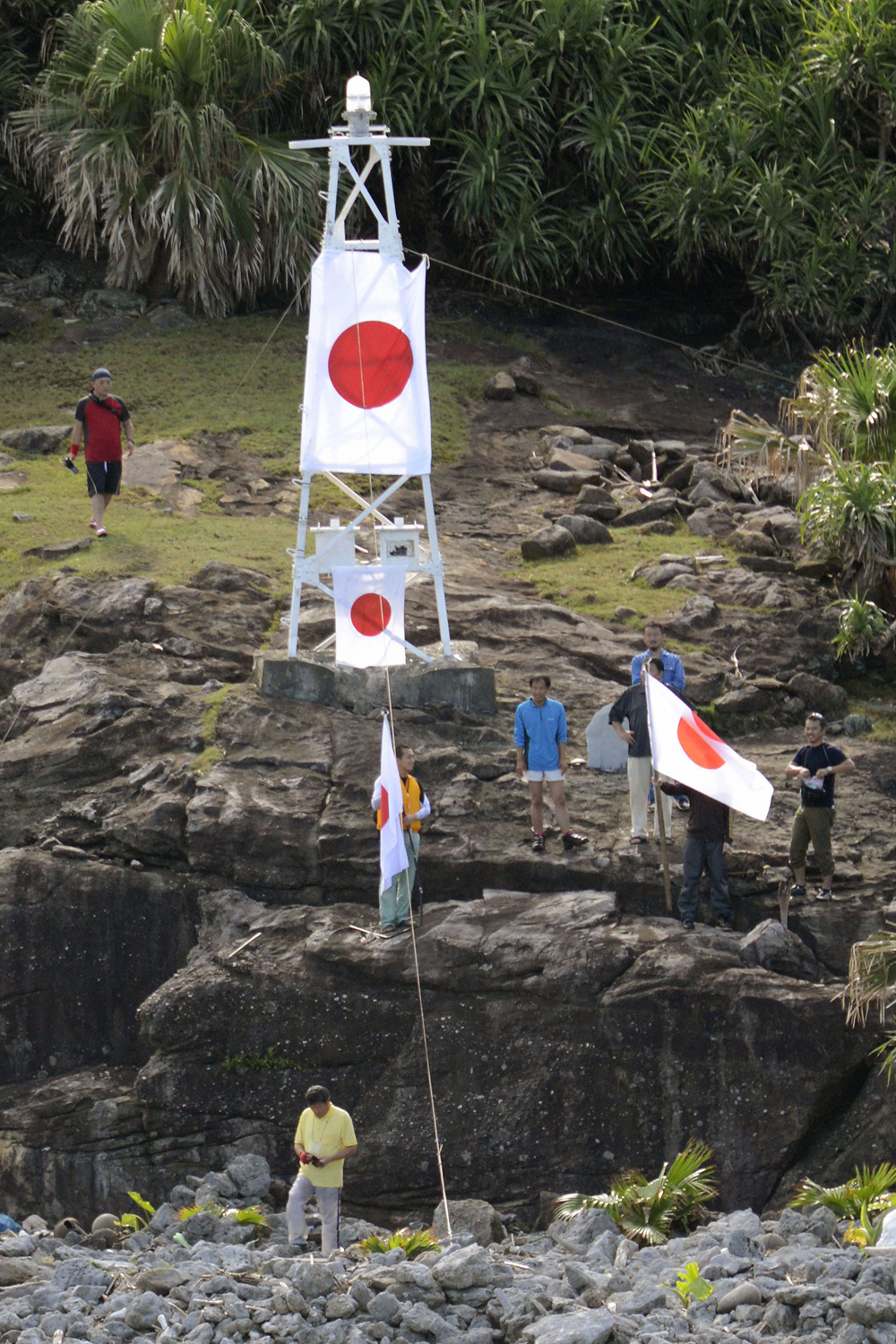 Japán nacionalisták kitűzik országuk zászlaját a vitatott státusú, lakatlan szigetek egyikén