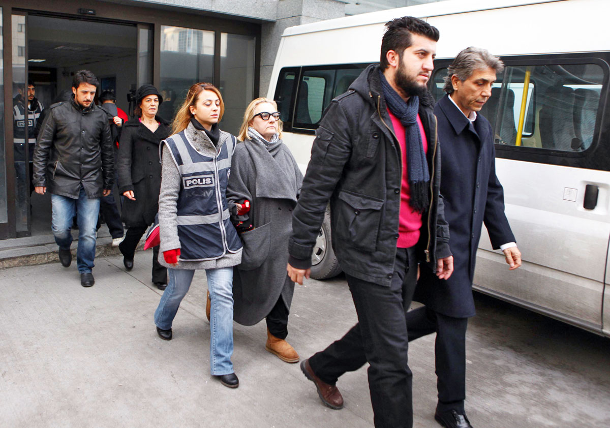 Rendőrök kísérik el Mustafa Demirt (jobbra), Isztambul Fatih nevű negyedének polgármesterét