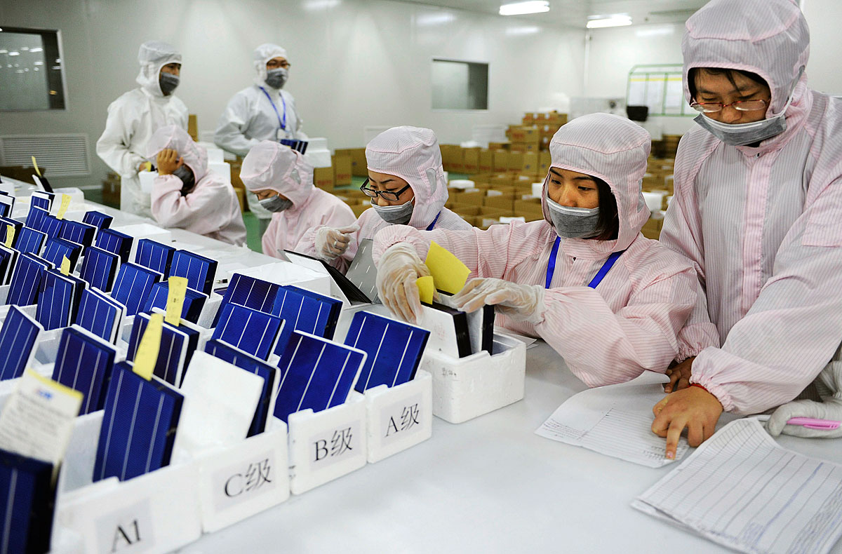 Employees inspect and sort solar panels into different quality categories at a workshop of LDK Solar company in Hefei, Anhui province November 10, 2011. China's Commerce Ministry said on Thursday it was 
