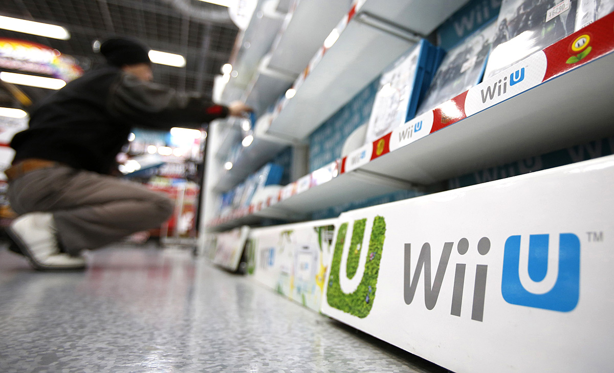 A man looks at software for Nintendo Co's Wii U game consoles at an electronics retail store in Tokyo January 20, 2014. Shares in Nintendo Co Ltd tumbled by nearly a fifth on Monday after it warned of a third straight year of operating losses, heapin