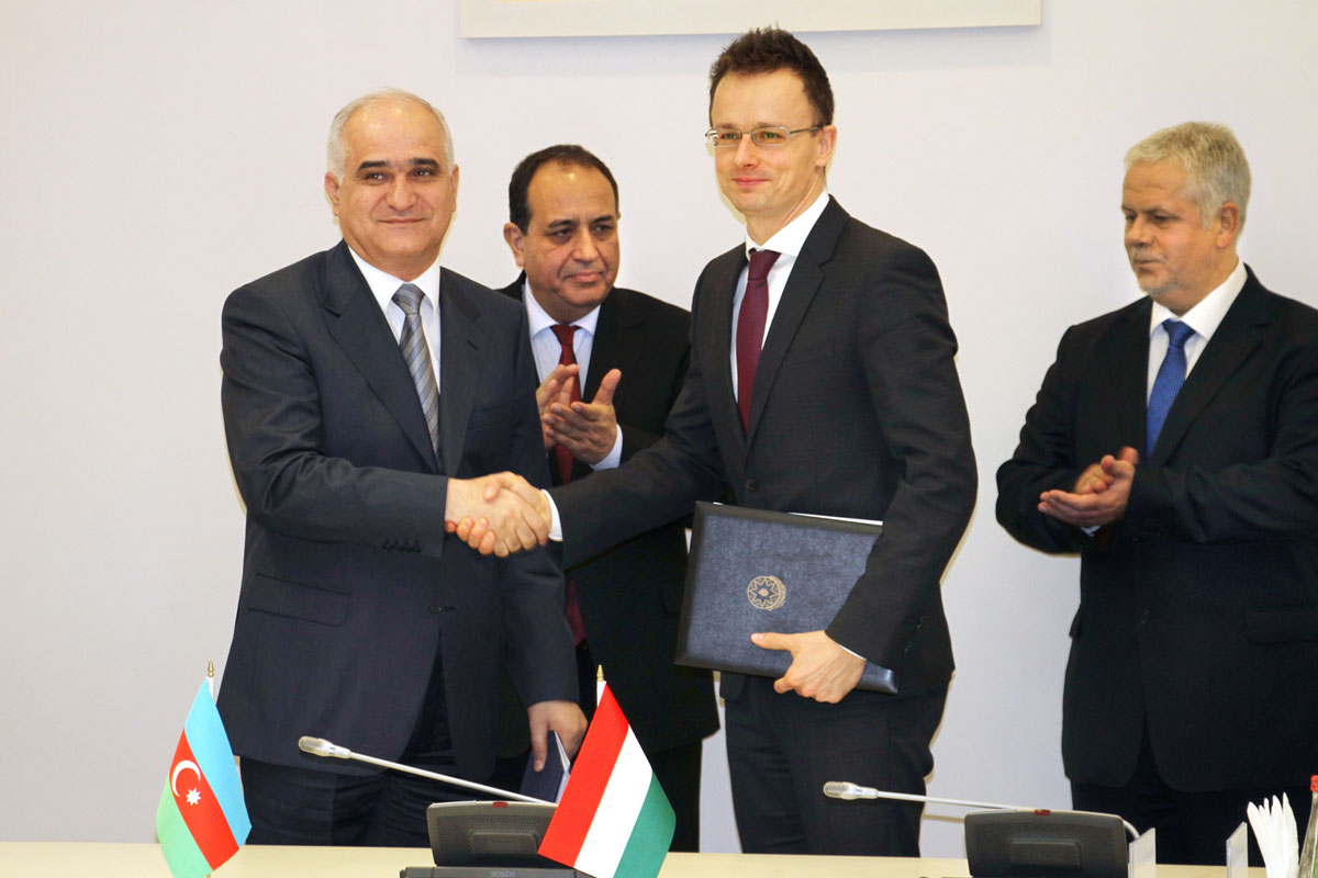 Szijjártó Péter (középen) kezet fog Shahin Mustafayev azeri gazdasági miniszterrel, a két ország gazdasági vegyes bizottságának azeri társelnökével, kezében a tegnap Bakuban aláírt megállapodás jegyzőkönyve