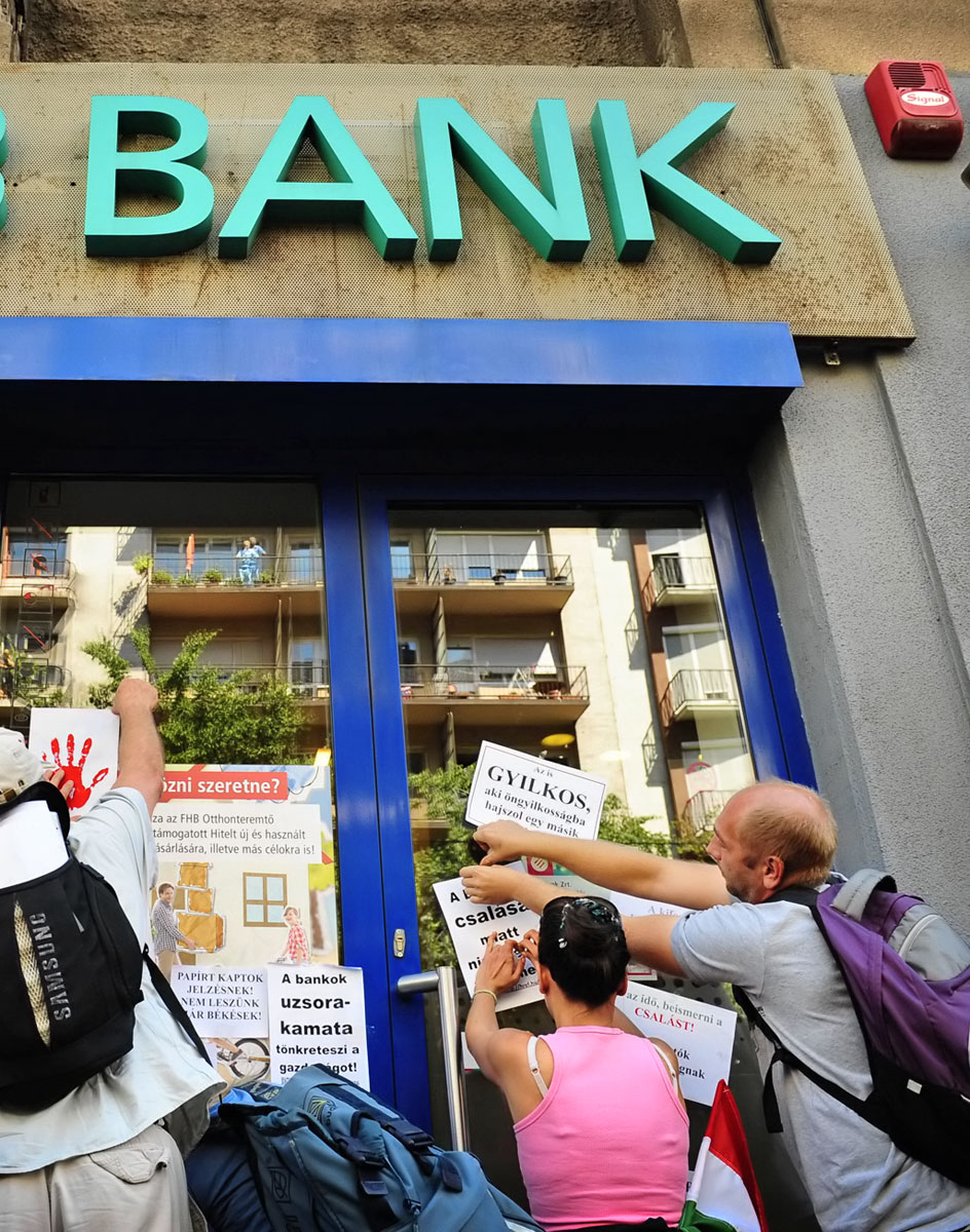 Demonstráló adósok ragasztják tele egy bank bejáratát