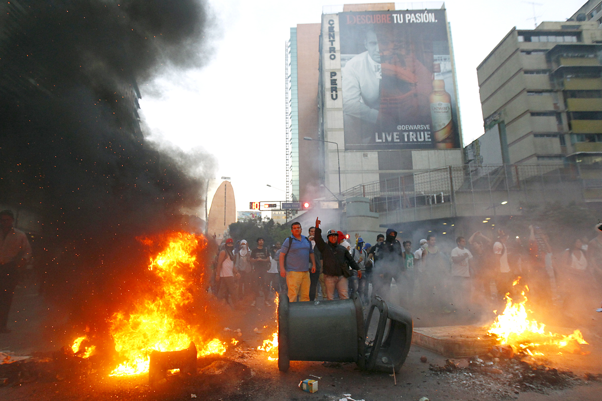 Demonstrators make a barricade of burning garbage during a protest against Venezuela's President Nicolas Maduro's government in Caracas February 12, 2014. A demonstrator was killed during an anti-government rally in Caracas on Wednesday, Reuters witn