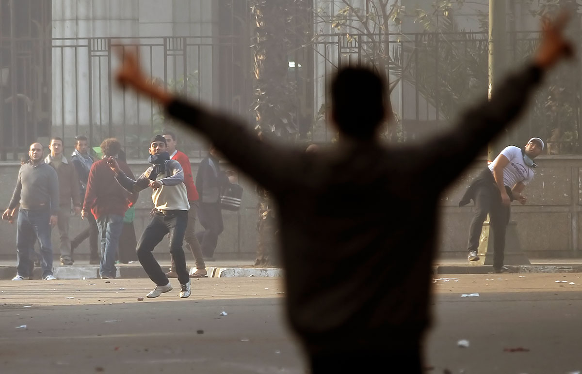 Murszi-ellenes tüntető a győzelem jelét mutatja a kairói összecsapások után