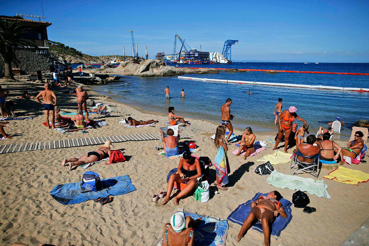 A Costa Concordiát tavaly szeptemberben az oldaláról álló helyzetbe fordították. A strandolókat nem zavarta a közelben lévő hajóroncs