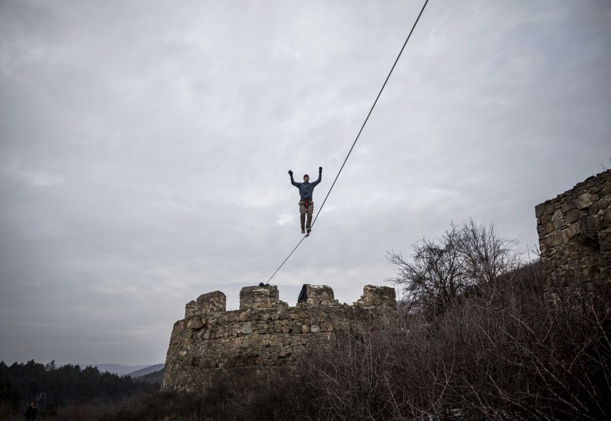 Egy slacker egyensúlyoz egy kifeszített hevederen az egri vár másának romjai között 2014. február 1-jén
