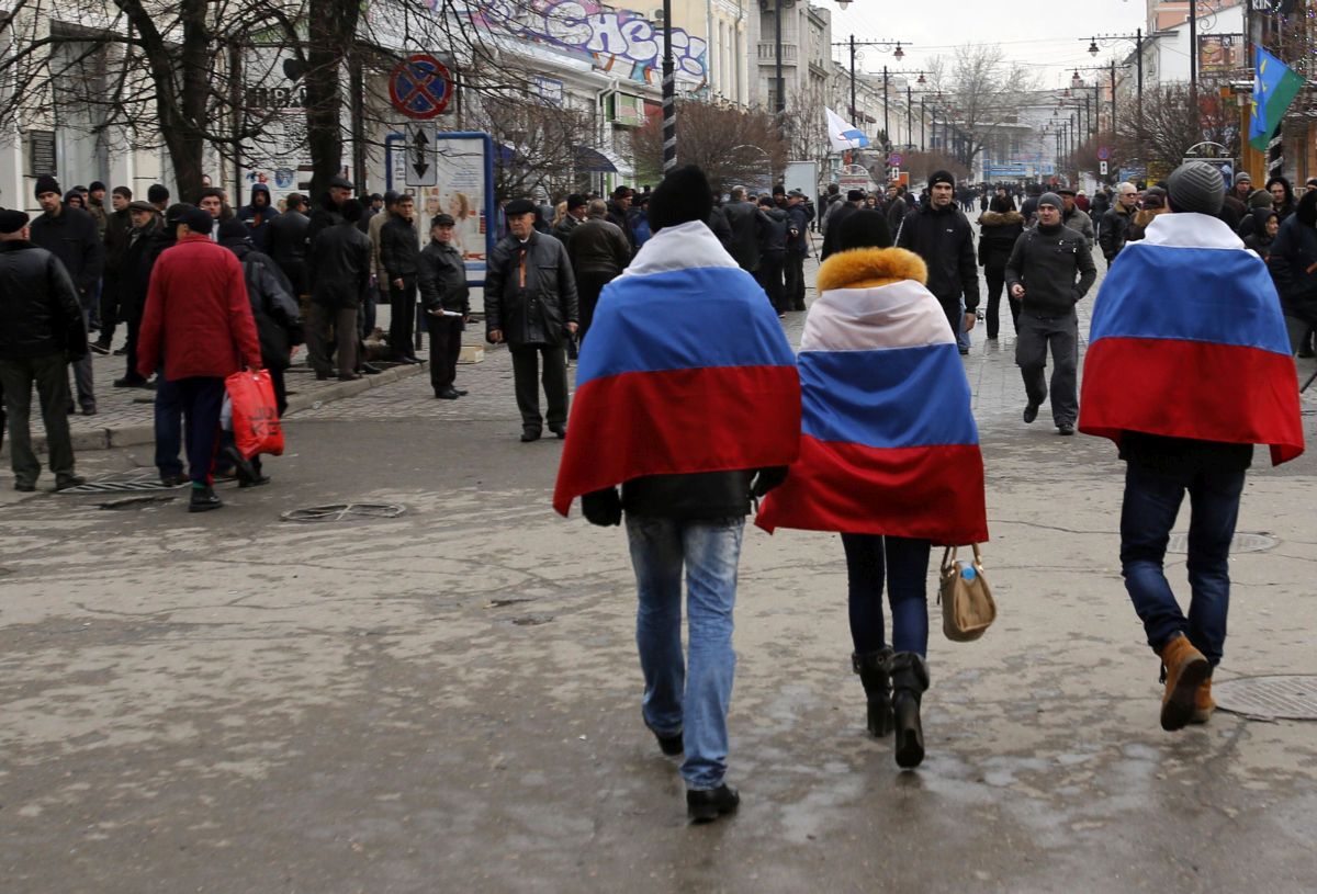 Orosz zászlós járókelők az Ukrajnához tartozó Krími Autonóm Köztársaság székvárosában, Szimferopolban