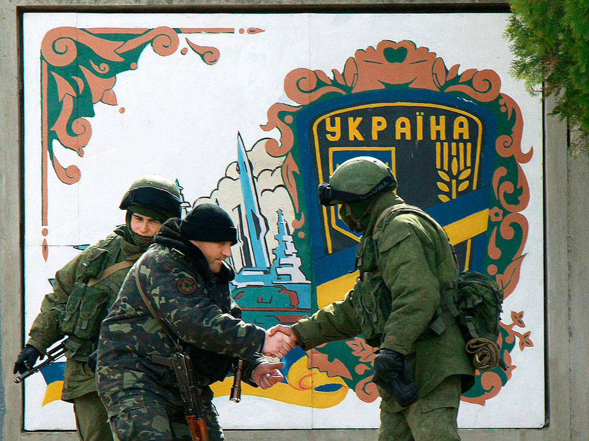 Ukrán katona (balról a második) kezet ráz egy orosz fegyveressel a Krím félszigeten