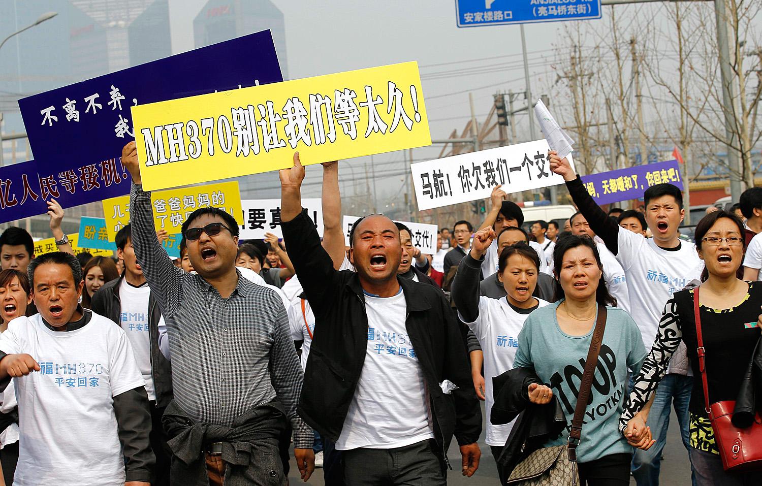 Tüntető családtagok a pekingi maláj nagykövetség előtt. Kapaszkodnak az utolsó utáni szalmaszálba is