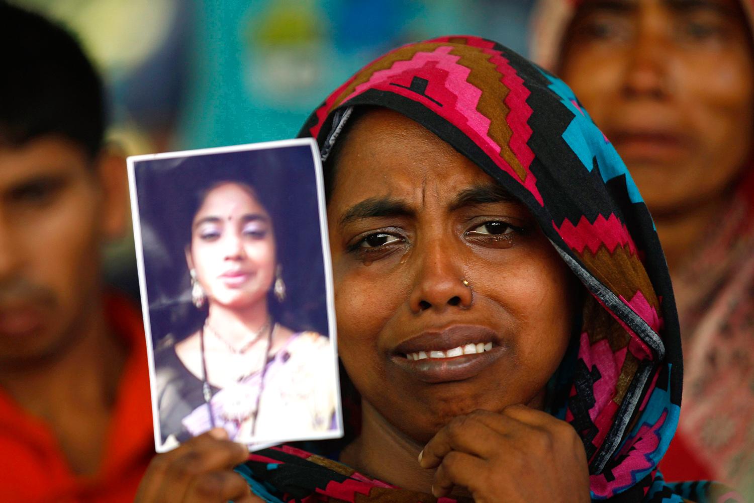 Eltűnt rokonának fotóját mutatja egy nő a tragédia első évfordulóján