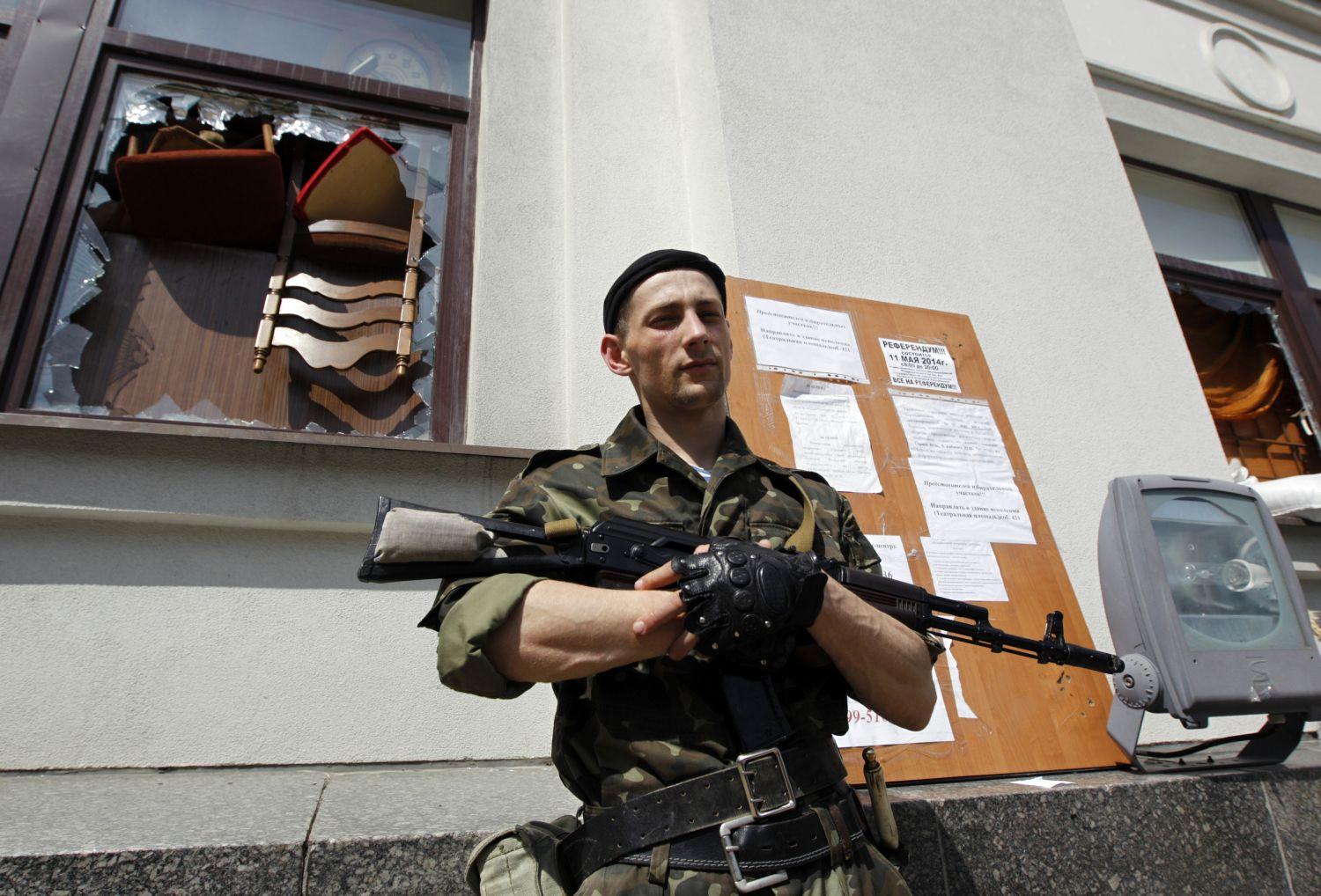 Orosz önkéntes őrzi a választóhelységet Luganszkban