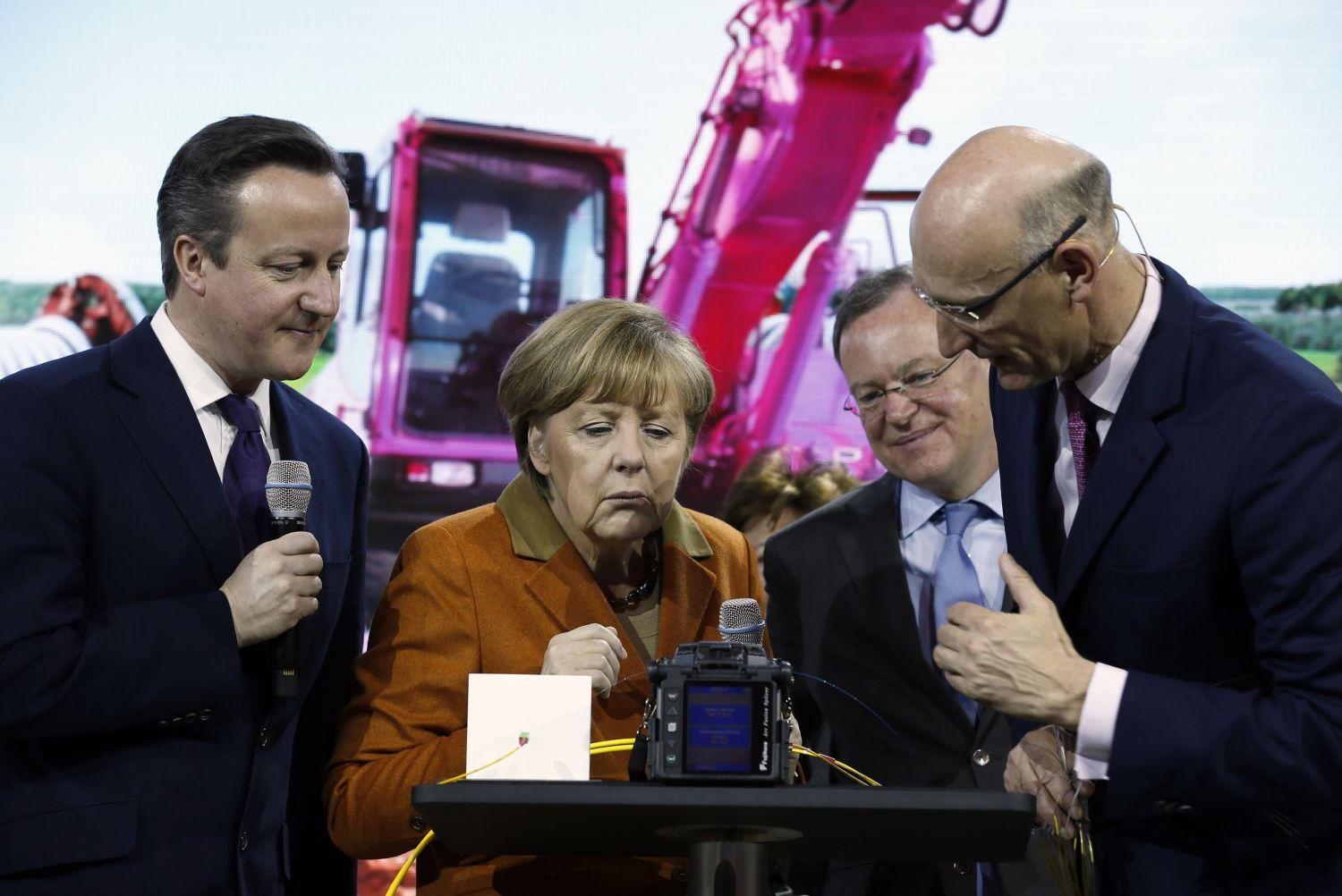 A Deutsche Telekom vezérigazgatója (jobbra) a legmodernebb adatkábelt mutatja meg a német és a brit kormányfőnek