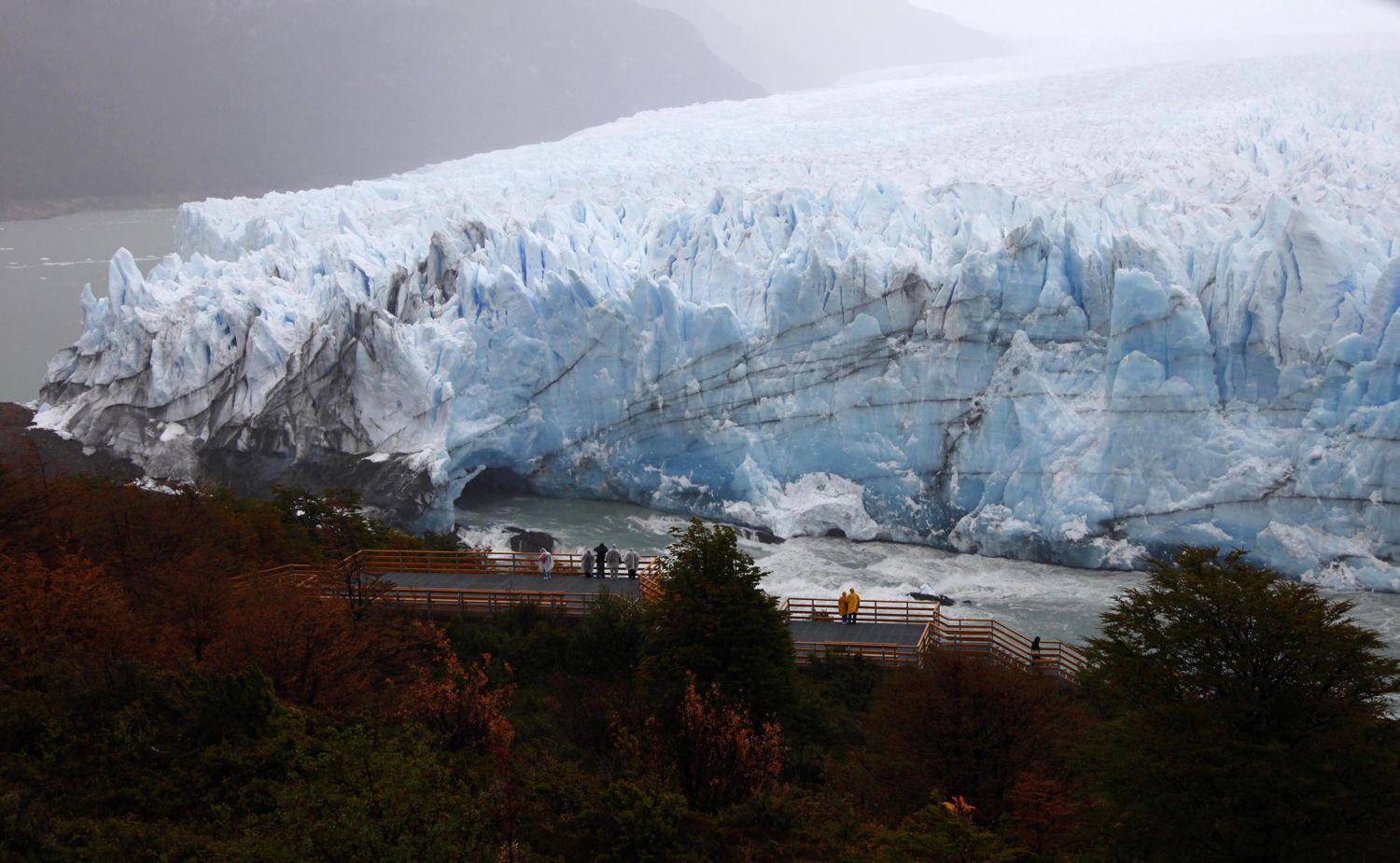 Turisták figyelik, ahogy a Perito Moreno-gleccserből leszakadnak kisebb darabok