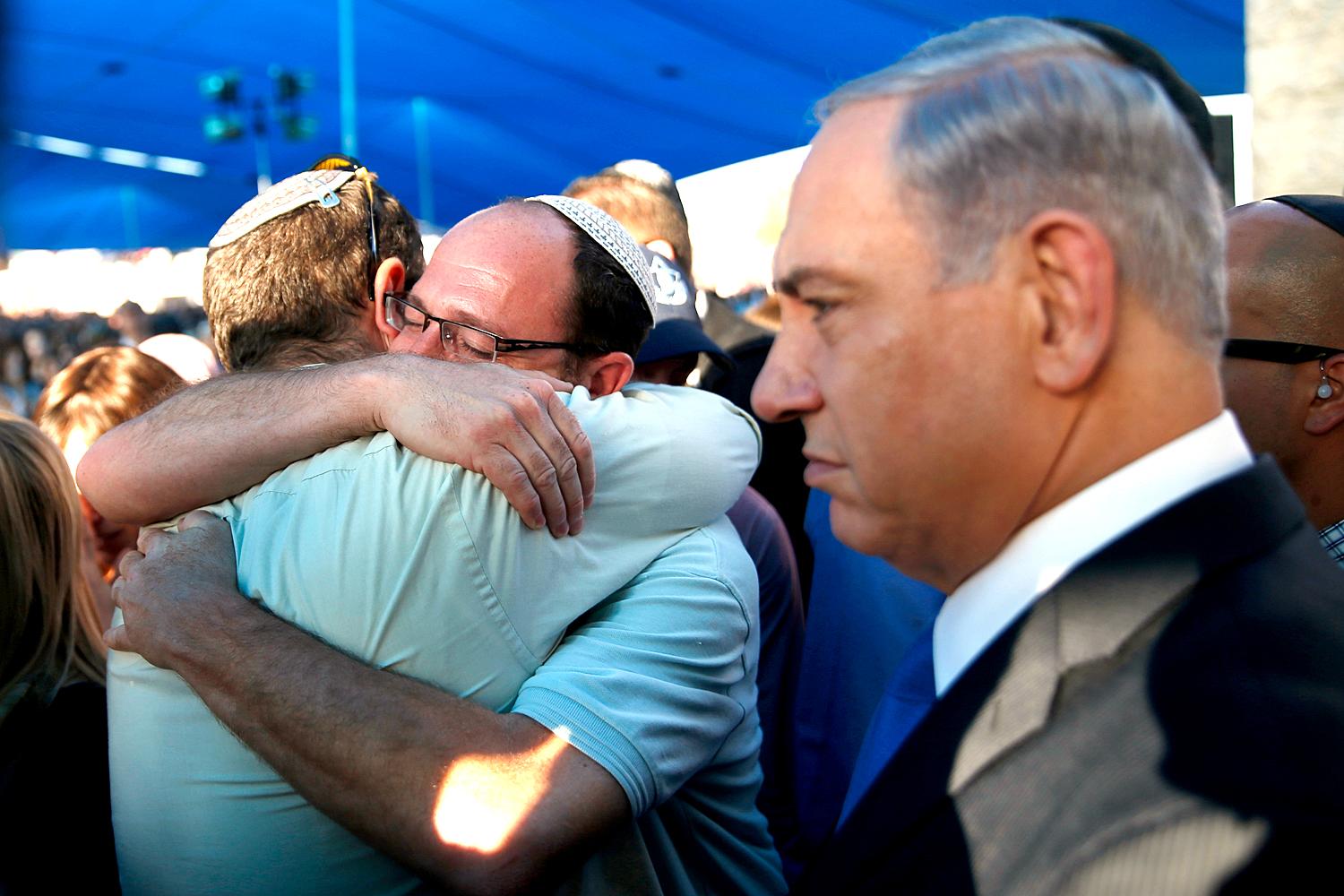Két gyászoló apa ölelkezik a meggyilkolt tinédzserek ravatalánál Netanjahu izraeli kormányfő jelenlétében