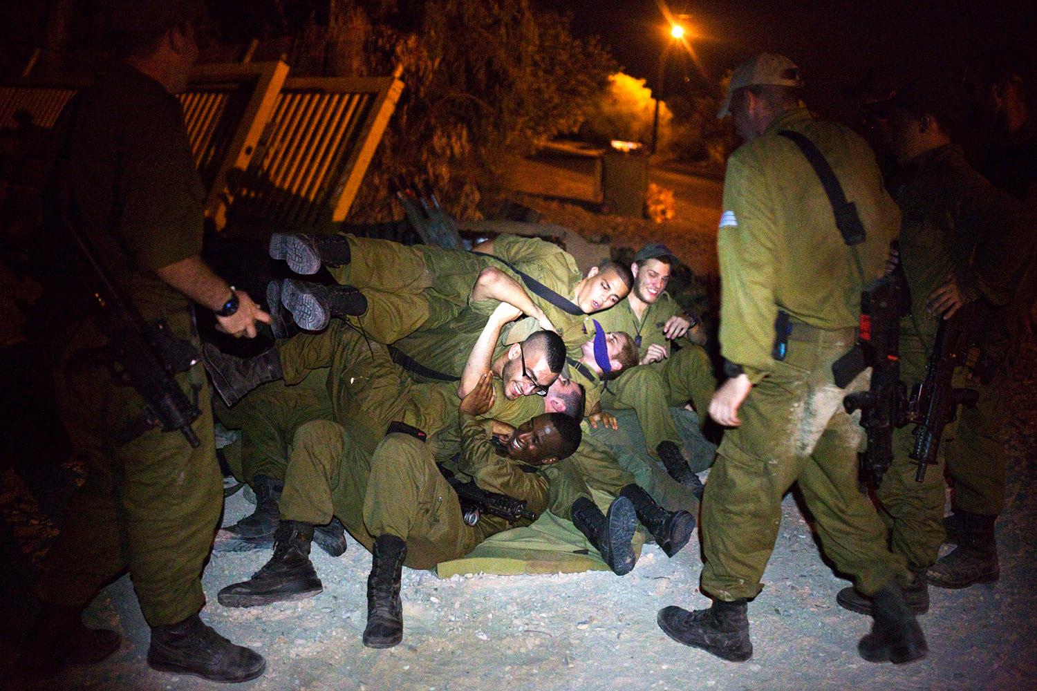 A Gázai övezet határán felsorakozott izraeli hadsereg katonái szórakoznak menetparancs előtt