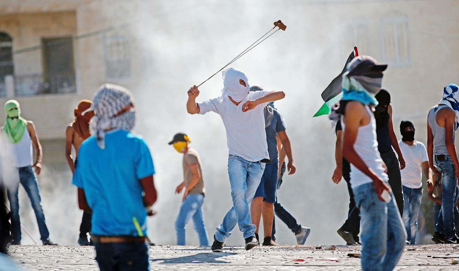 Palesztin tüntető parittyával támad az izraeli rendőrökre. Kiszolgáltatottak és elkeseredettek