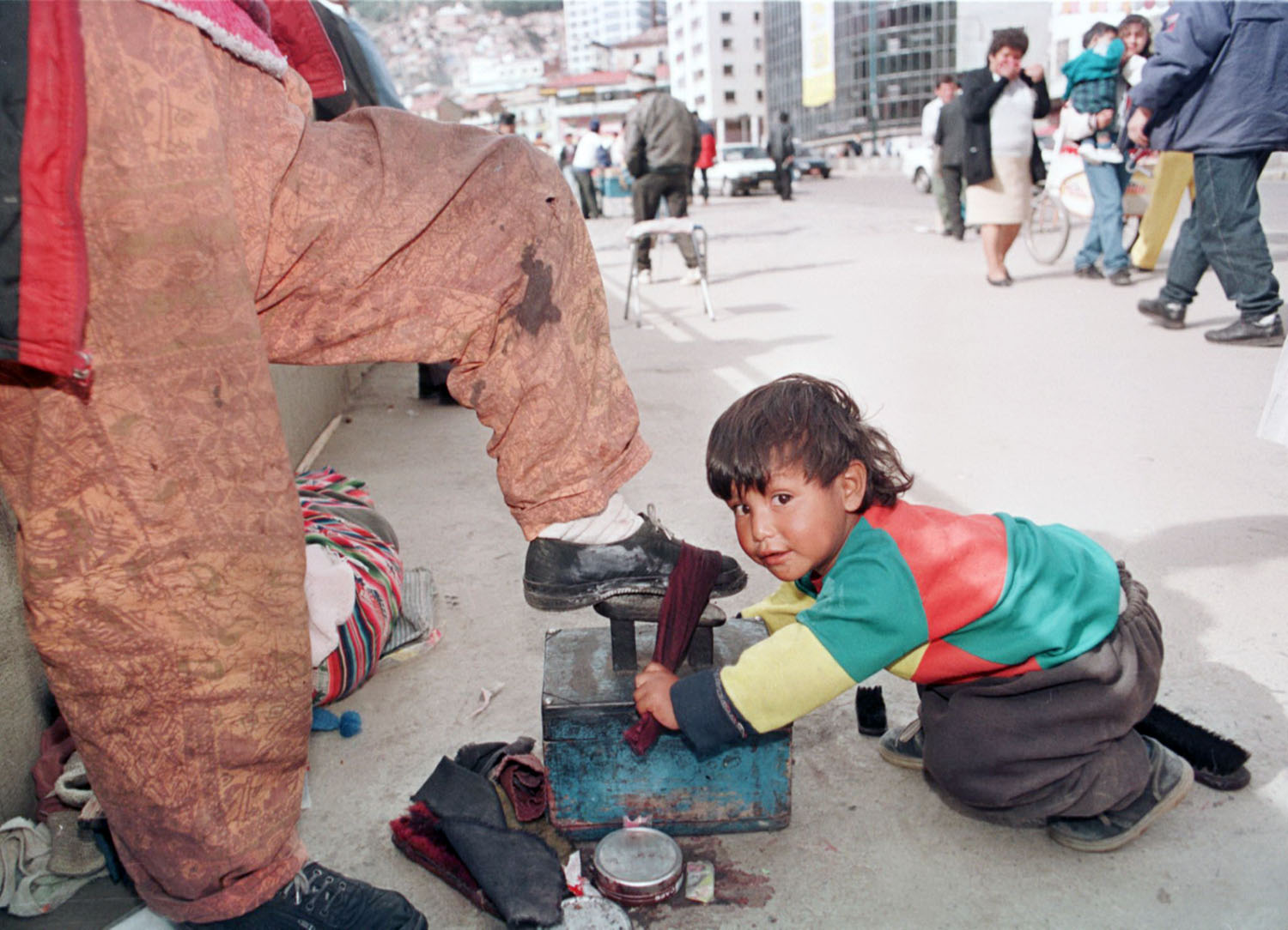 A négyéves Joel a cipőpucolást tanulja a bolíviai főváros, La Paz főterén. A család számára nélkülözhetetlen bevétel?