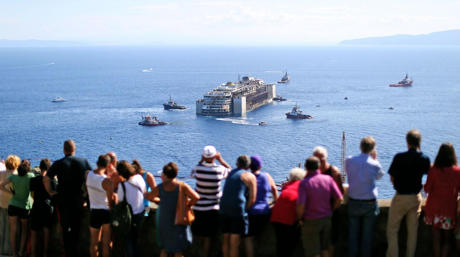 Tömegek várják a Costa Concordia érkezését. A hajó utolsó útjáról még több képet láthat ide kattintva.
