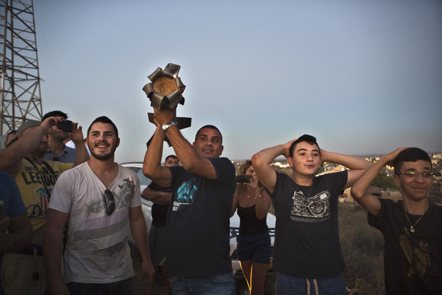 Egy Gázából kilőtt rakétát szednek össze izraeliek a vasárnapi tűzsszünet alatt Szderot határában