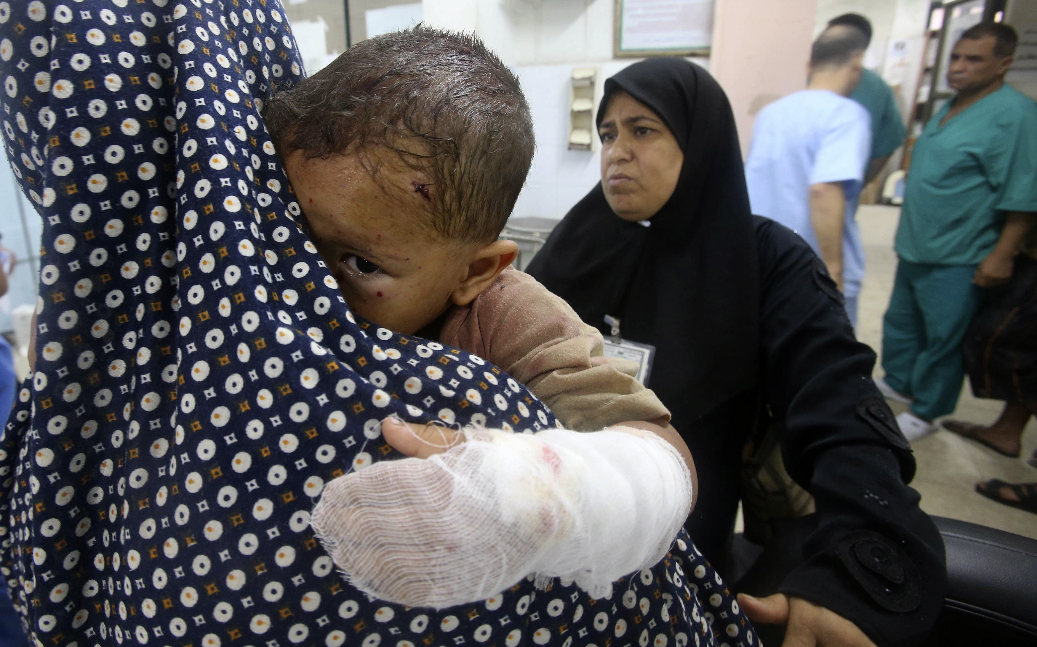 Egy sérült palesztin gyereket tart nagyanyja egy gázai kórház előtt