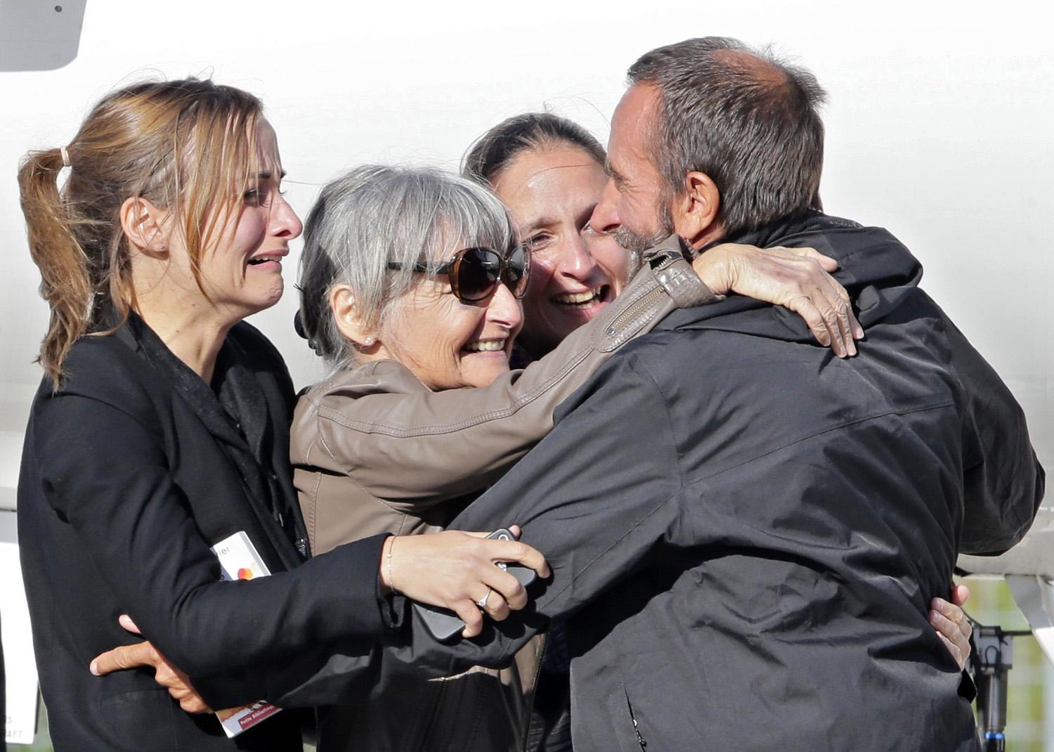 Egy kiszabadított túsz (jobbra) viszontlátja a családját egy francia katonai repülőtéren