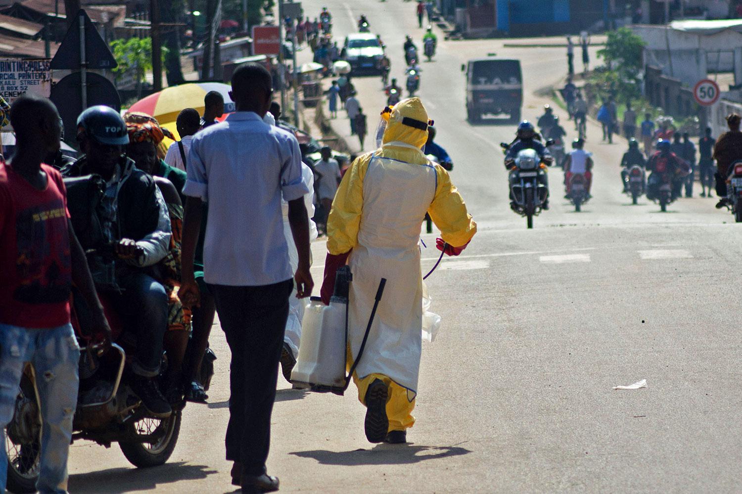 Fertőtlenítővel Sierra Leona harmadik legnagyobb városának, Kenemának az egyik utcáján