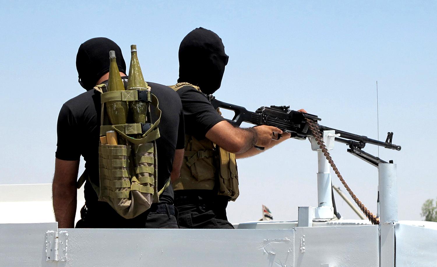 A szunnita szélőségesek ellen harcoló félkatonai szervezet, a Mehdi Hadserege két tagja  Tikritben. Szaddám Huszein szülővárosa most az Iszlám Állam (IS kezén van  