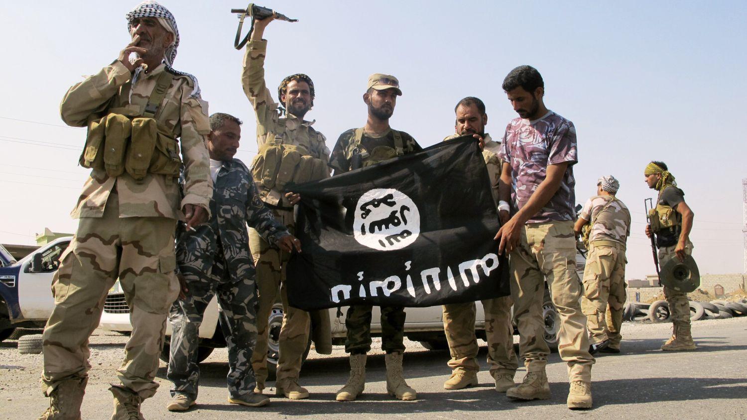 Ünneplő síita milicisták az IS egyik zászlajával Amerliben