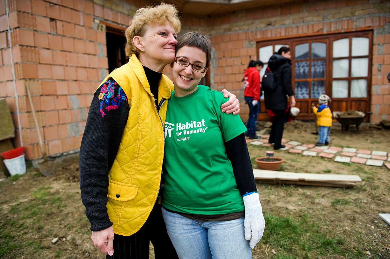 Magyar háztulajdonos nő és amerikai diákönkéntes egy Habitat-munkán a Nógrád megyei Berkenyén