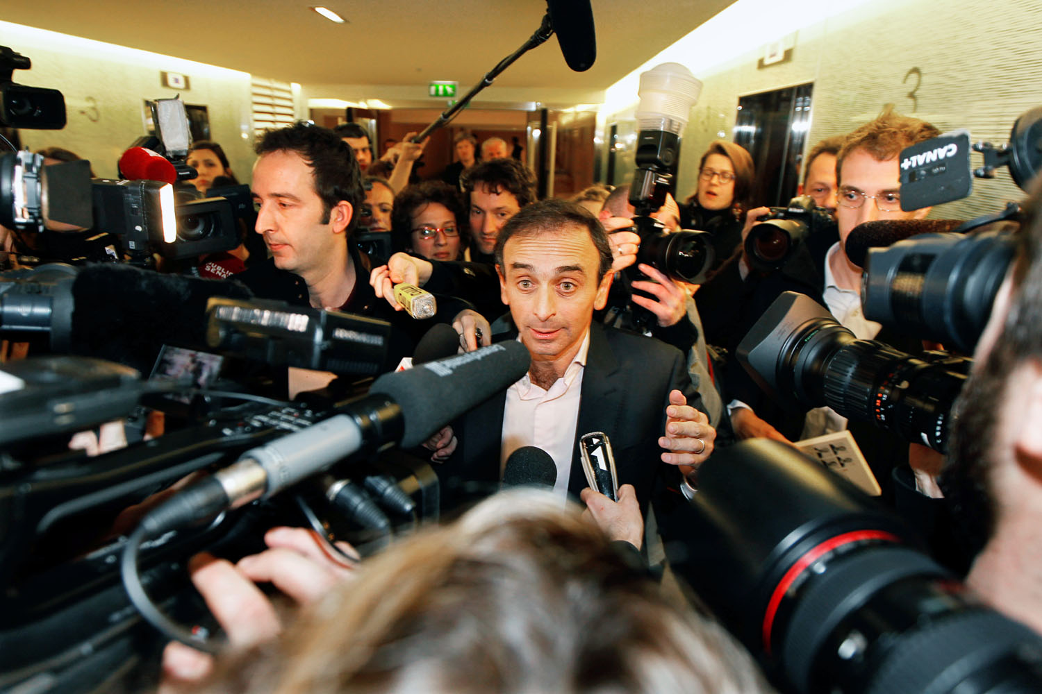 Éric Zemmour (középen) újságírók gyűrűjében. A francia népesség ötödét tekinti idegennek