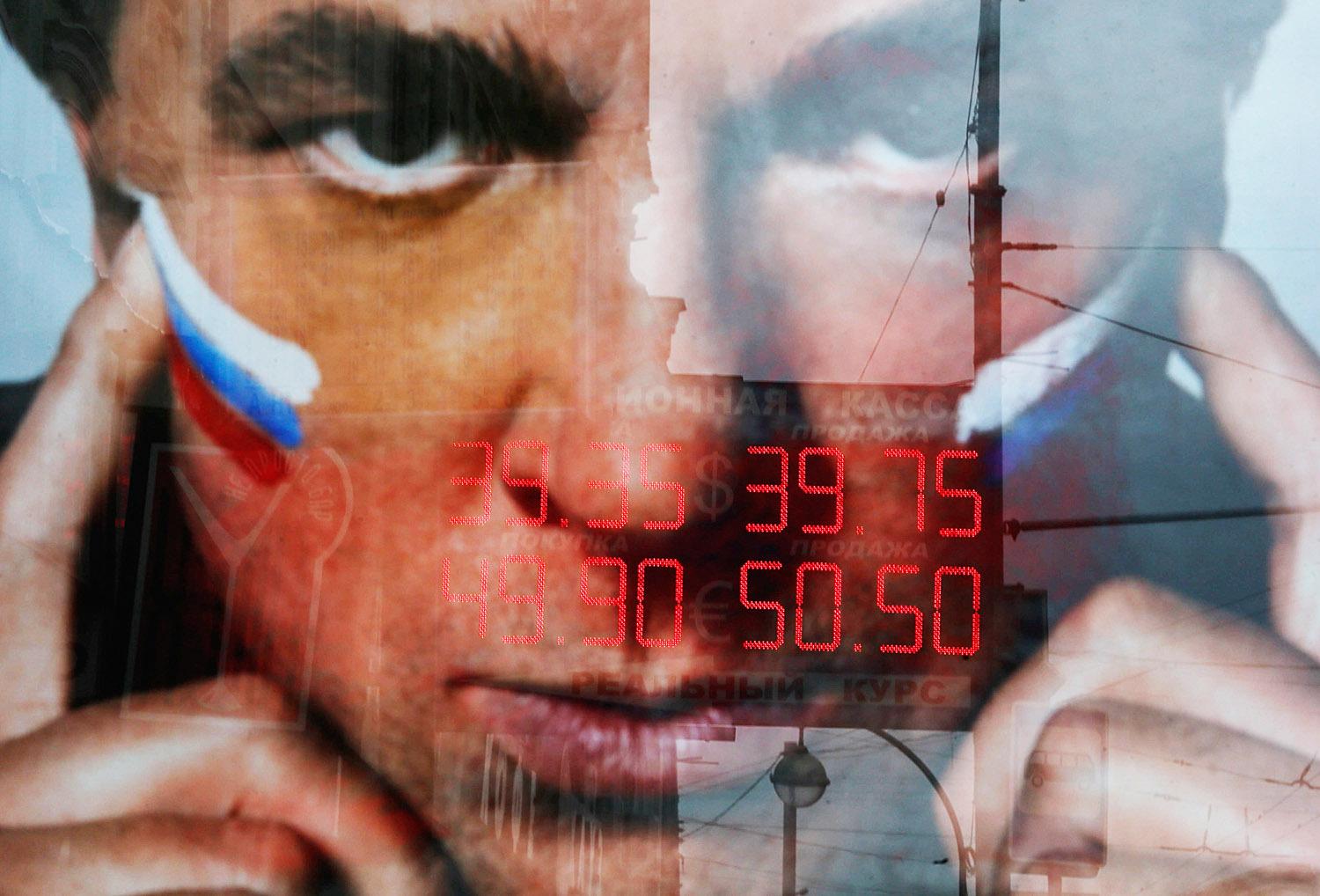 Moszkvai kirakatban tükröződő szeptember végi dollár- és euróárfolyamok. Zuhan a rubel