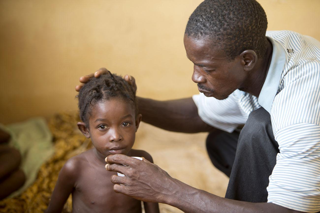 Gyermekét ápoló apa Sierra Leonében.