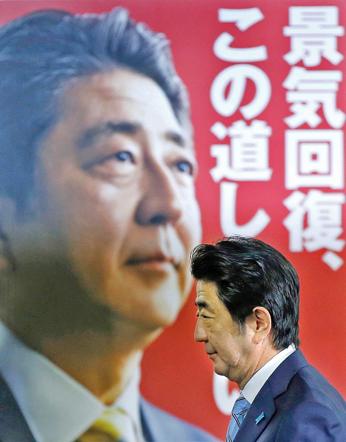 Abe Sindzó saját választási plakátja előtt. Hosszú távon kell vele számolni