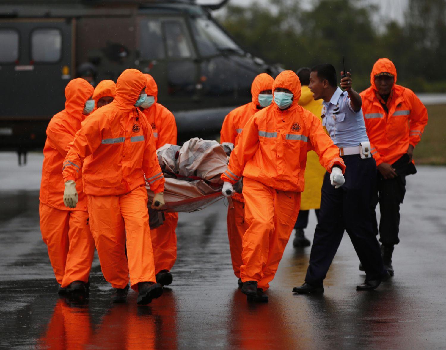 Mentőegységek a QZ8501-es járat egyik darabjábal