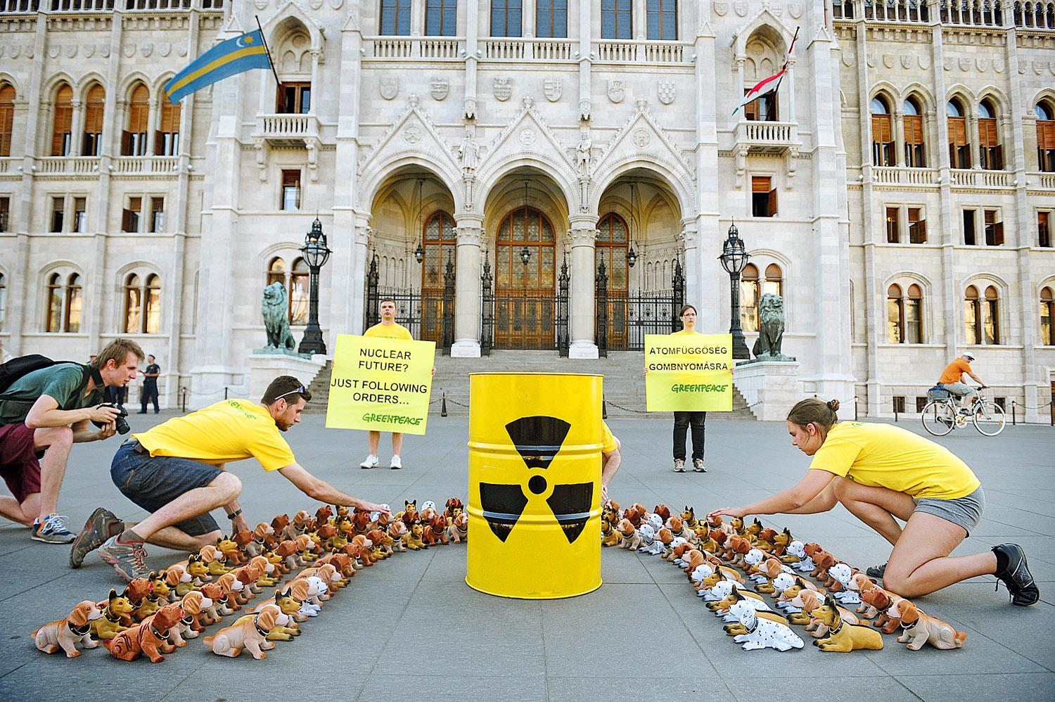 Bólogató kutyák – a Greenpeace aktivistái így szimbolizálták a paksi bővítésről szóló Orbán-Putyin szerződést szerződést elfogadó képviselőket a határozathozatal után