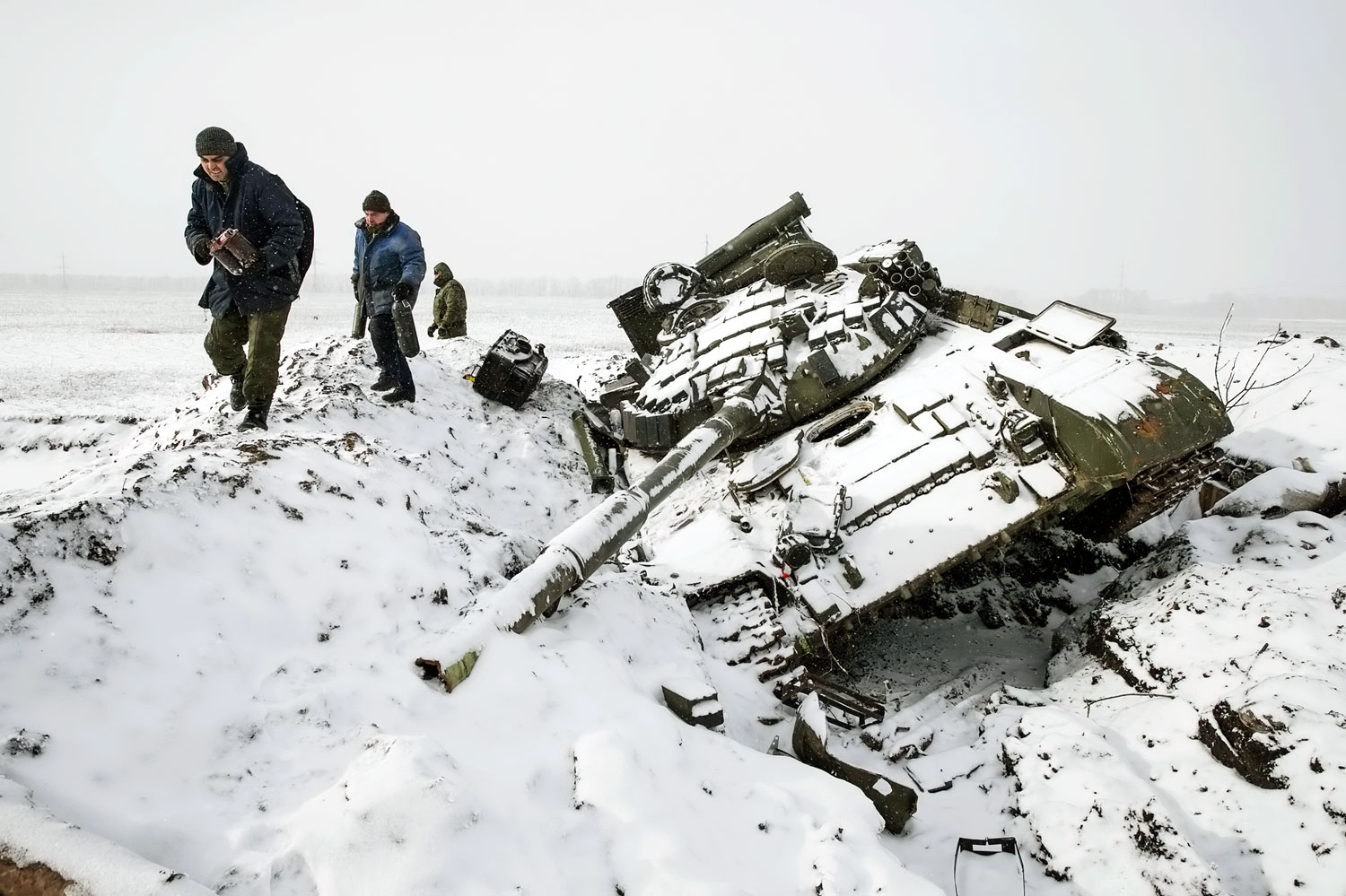 Szeparatisták gyűjtik össze egy kilőtt ukrán tank darabjait Debalcevétől tíz kilométerre